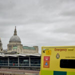 St Paul's Cathedral and City skyline in background and corner of an LAS ambulance in foreground